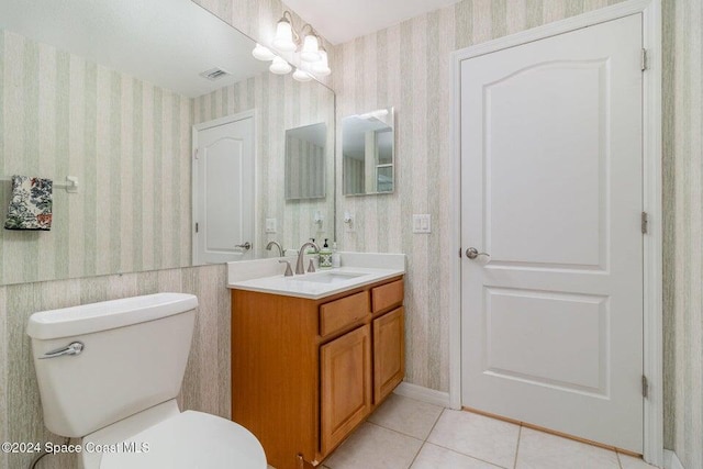 bathroom with tile patterned flooring, vanity, a chandelier, and toilet