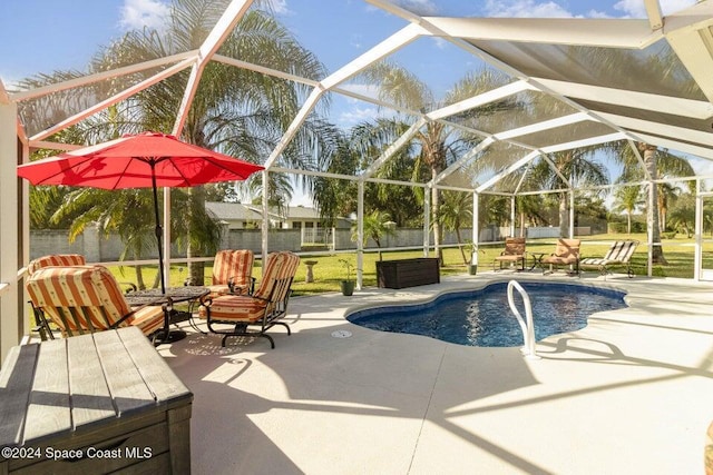 view of swimming pool with a patio, a lanai, and a lawn