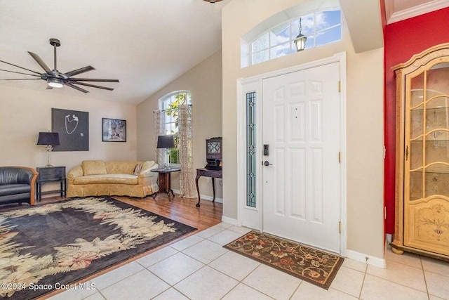 entrance foyer with lofted ceiling, light tile patterned floors, and ceiling fan