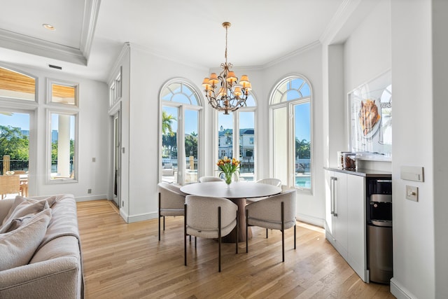 dining room with an inviting chandelier, crown molding, and light hardwood / wood-style floors