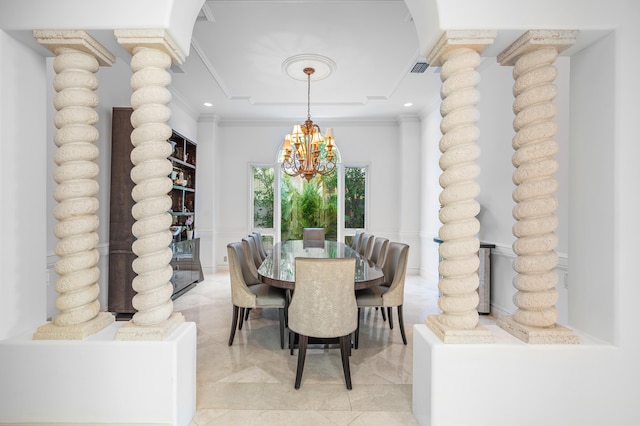 dining space featuring decorative columns, crown molding, and a chandelier