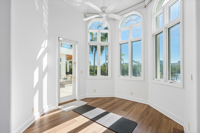 unfurnished sunroom featuring a healthy amount of sunlight and ceiling fan