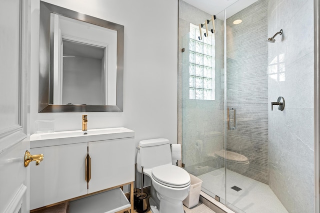 bathroom with vanity, a shower with shower door, and toilet