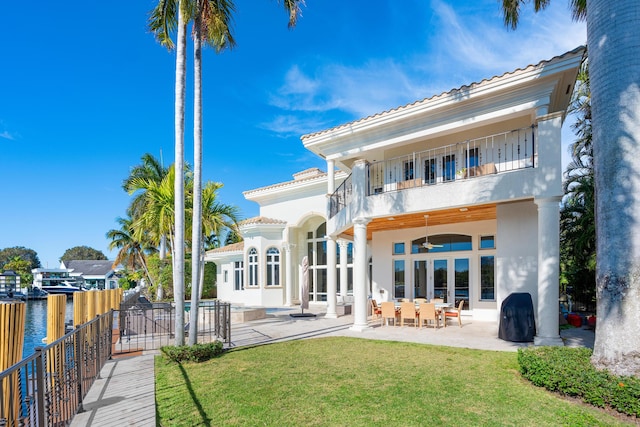 back of house with french doors, a patio area, a balcony, a lawn, and ceiling fan