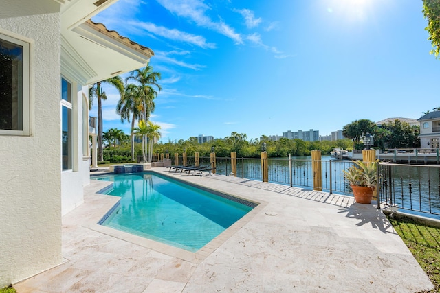 view of pool with a patio area and a water view