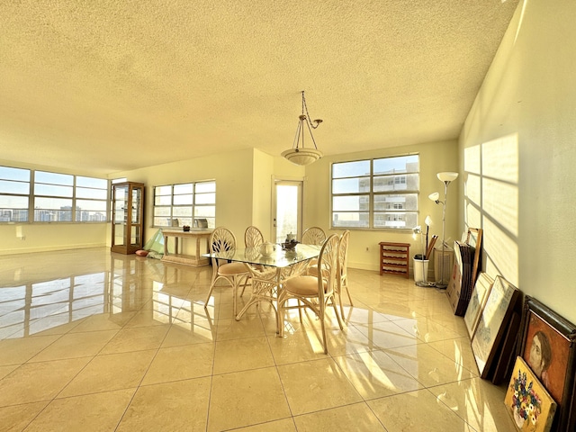 dining space featuring a textured ceiling and light tile patterned floors