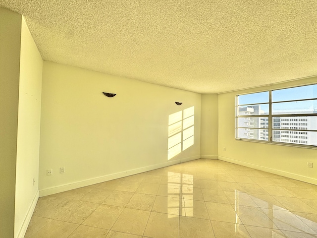 tiled empty room with a textured ceiling