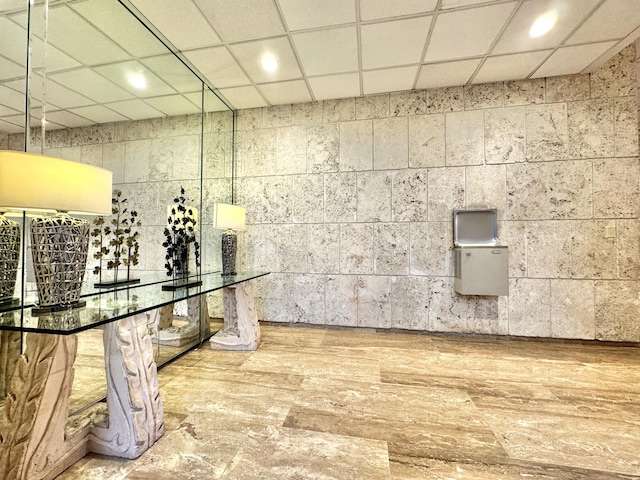 bathroom featuring wood-type flooring and a drop ceiling