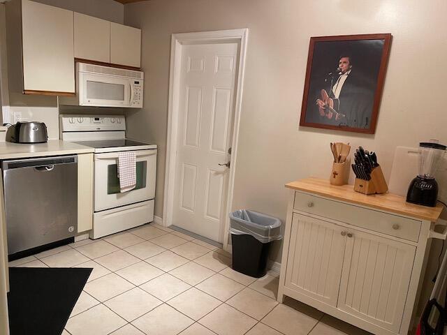 kitchen featuring light tile patterned floors and white appliances