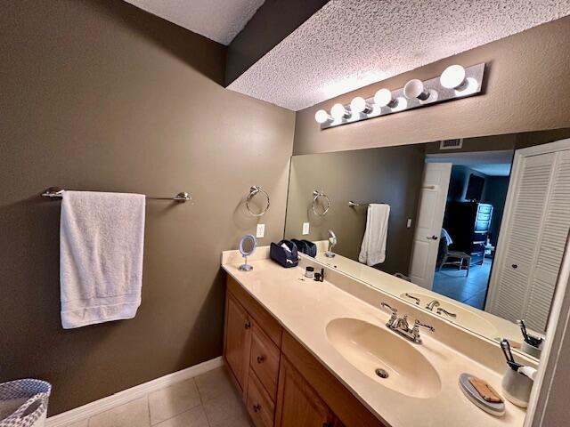 bathroom featuring tile patterned floors, vanity, and a textured ceiling