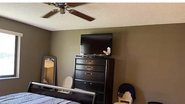 bedroom featuring ceiling fan and a textured ceiling