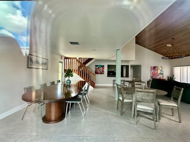 tiled dining space with vaulted ceiling and wood ceiling