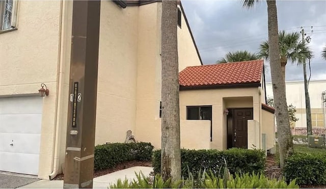 doorway to property with a garage and central AC unit