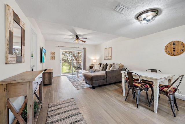 interior space featuring ceiling fan, a textured ceiling, and light wood-type flooring