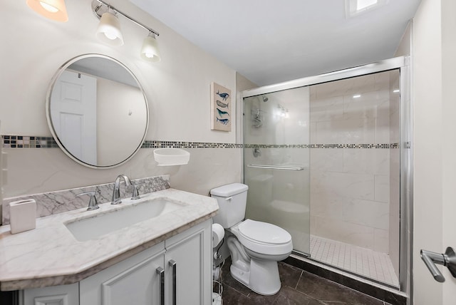 bathroom with walk in shower, vanity, toilet, and tile walls