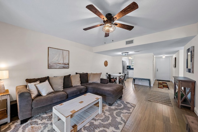 living room featuring hardwood / wood-style floors and ceiling fan