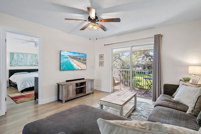 living room featuring ceiling fan and light hardwood / wood-style floors