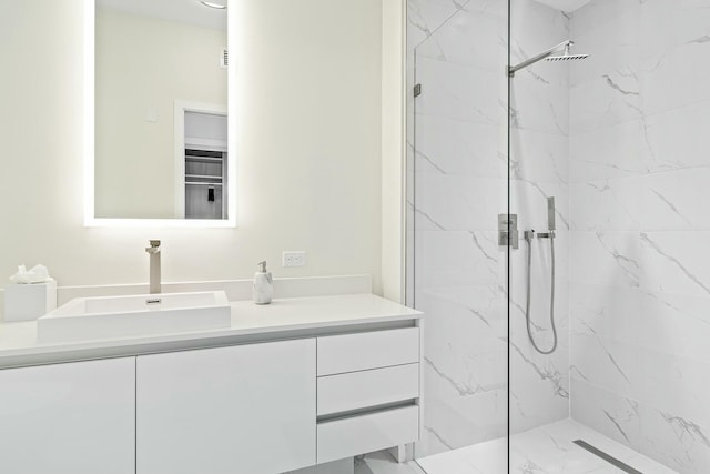 bathroom with vanity and a tile shower