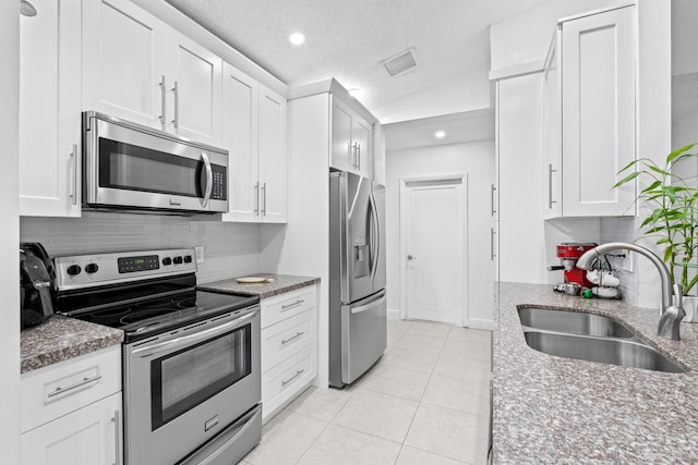 kitchen featuring white cabinetry, appliances with stainless steel finishes, sink, and light stone counters