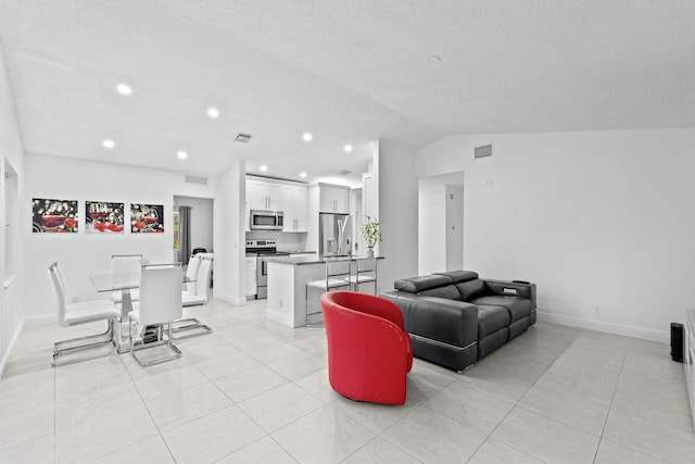 tiled living room featuring lofted ceiling and a textured ceiling