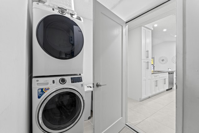 washroom featuring stacked washer / drying machine, sink, and light tile patterned flooring