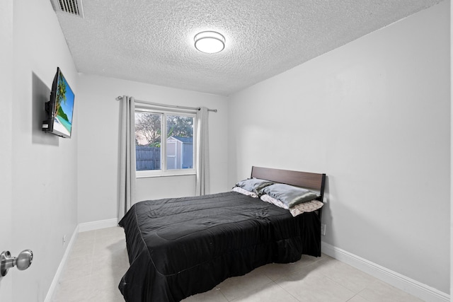 tiled bedroom with a textured ceiling