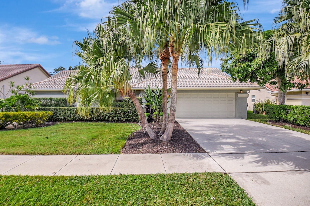 view of front of property featuring a garage and a front lawn