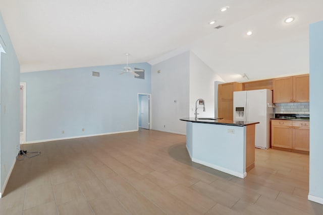 kitchen featuring high vaulted ceiling, sink, decorative backsplash, white fridge with ice dispenser, and ceiling fan