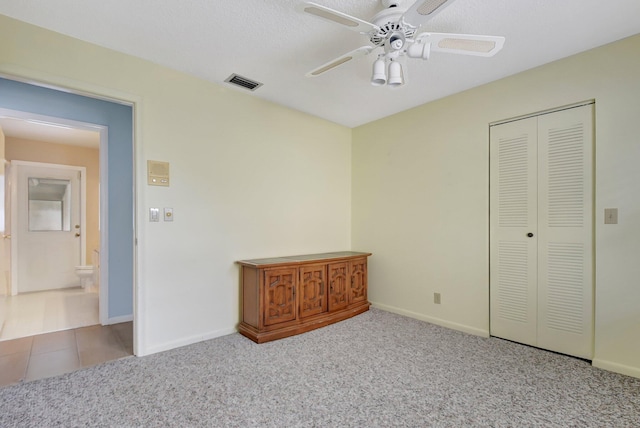 unfurnished bedroom featuring ceiling fan, a closet, and light carpet