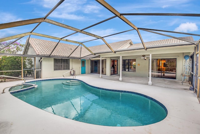 view of swimming pool with an in ground hot tub, ceiling fan, glass enclosure, and a patio