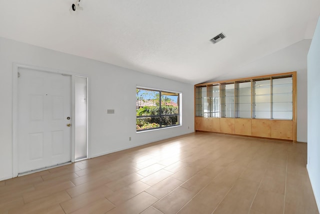 unfurnished living room featuring lofted ceiling