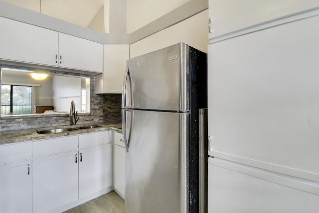 kitchen featuring white cabinetry, white fridge, sink, and stainless steel fridge