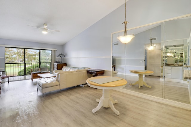 living room with ceiling fan, wood-type flooring, and high vaulted ceiling