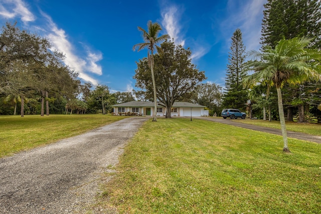 view of front of house featuring aphalt driveway, a garage, and a front lawn