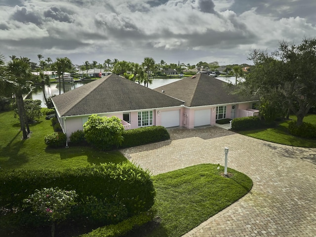 single story home featuring a garage, a water view, and a front yard