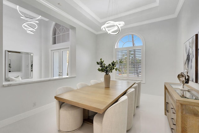 dining space featuring a tray ceiling, ornamental molding, and an inviting chandelier