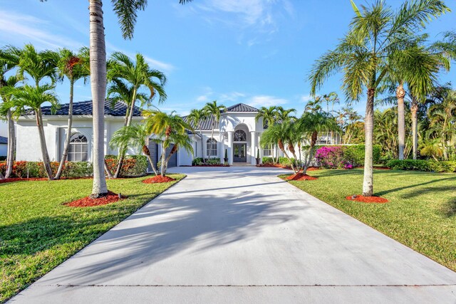 11960 Torreyanna Cir, West Palm Beach, FL 33412 - mediterranean / spanish house with concrete driveway, a front yard, a garage, and stucco siding