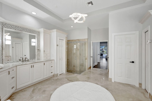 bathroom with a tray ceiling, vanity, an enclosed shower, and a chandelier