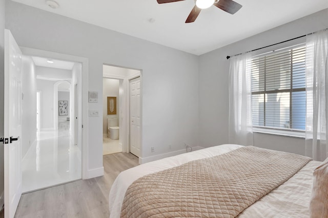 bedroom with light hardwood / wood-style floors, connected bathroom, and ceiling fan