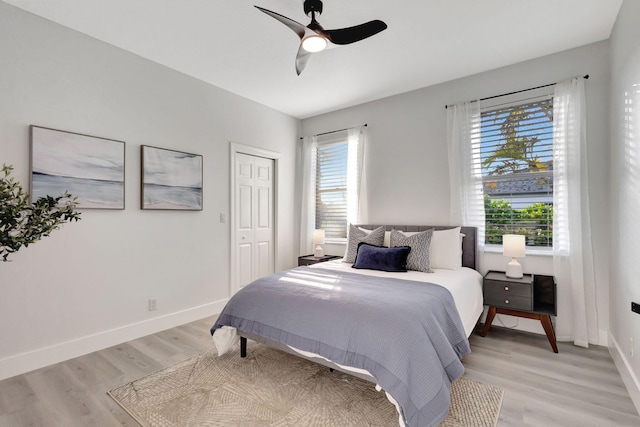 bedroom with light wood-type flooring, a closet, and ceiling fan