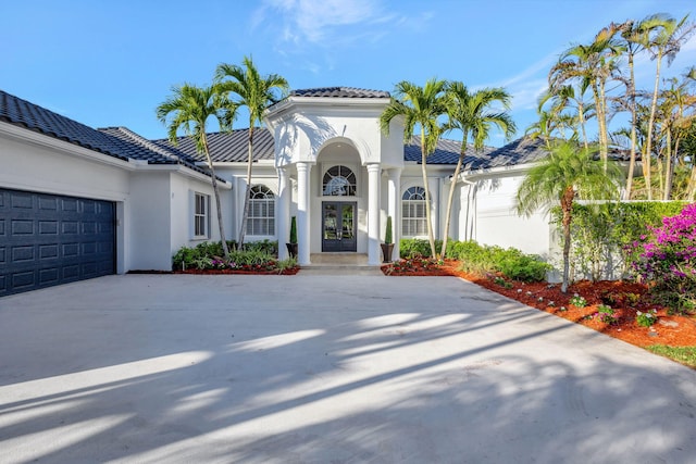 11960 Torreyanna Cir, West Palm Beach, FL 33412 - mediterranean / spanish-style house featuring french doors, driveway, stucco siding, a garage, and a tile roof