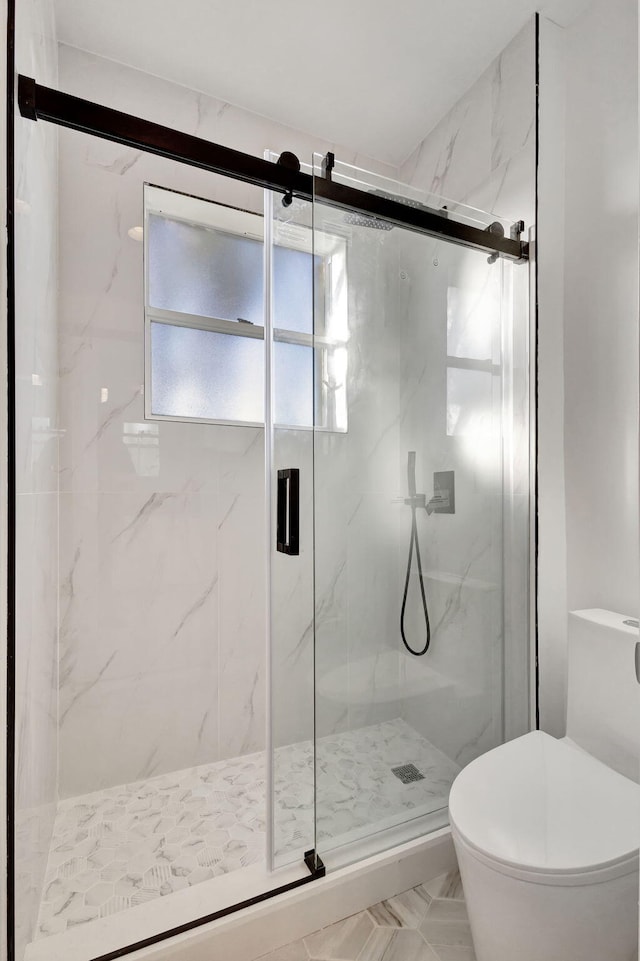 bathroom with toilet and a shower with shower door