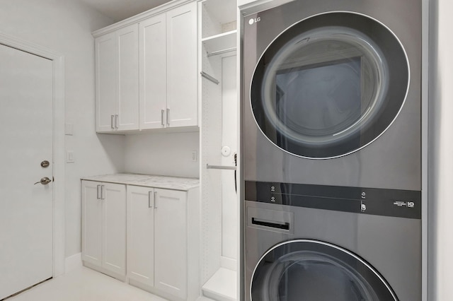 laundry room featuring cabinets and stacked washer and dryer