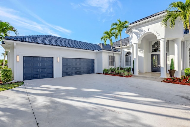 11960 Torreyanna Cir, West Palm Beach, FL 33412 - mediterranean / spanish-style house featuring an attached garage, a tile roof, driveway, and stucco siding