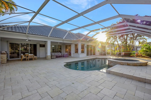 view of pool featuring a patio, outdoor lounge area, an in ground hot tub, and a lanai