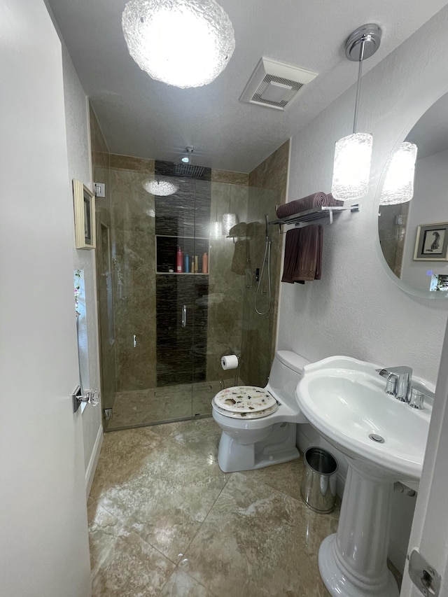 bathroom with a shower with shower door and toilet