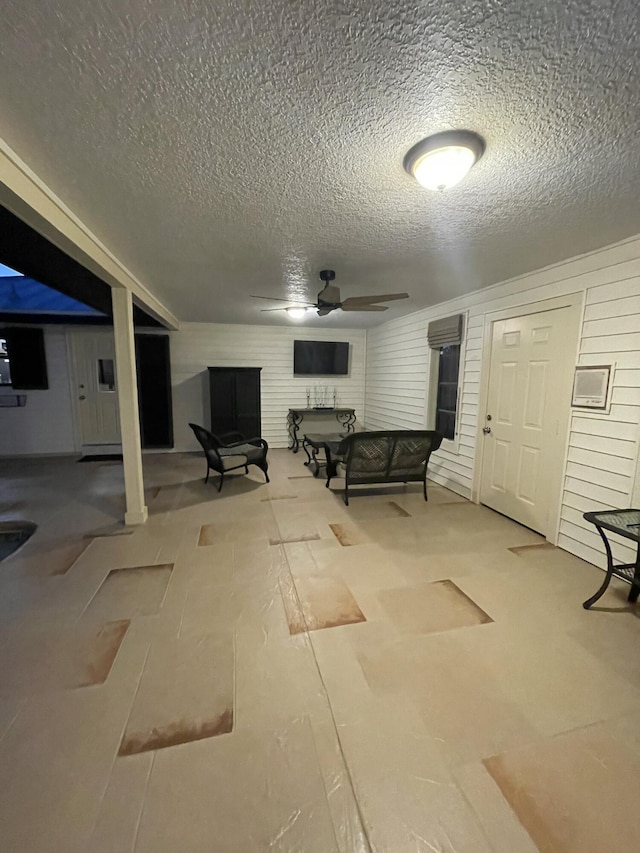 basement featuring a textured ceiling and ceiling fan