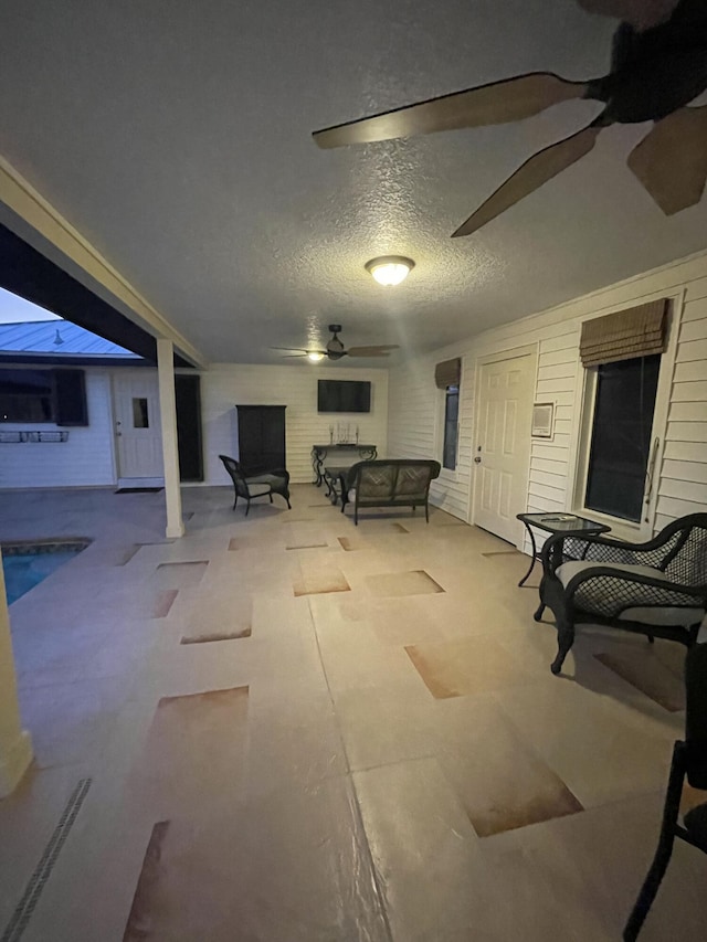 basement featuring a textured ceiling and ceiling fan