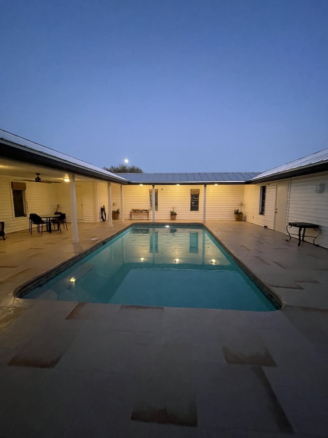 pool at dusk with a patio