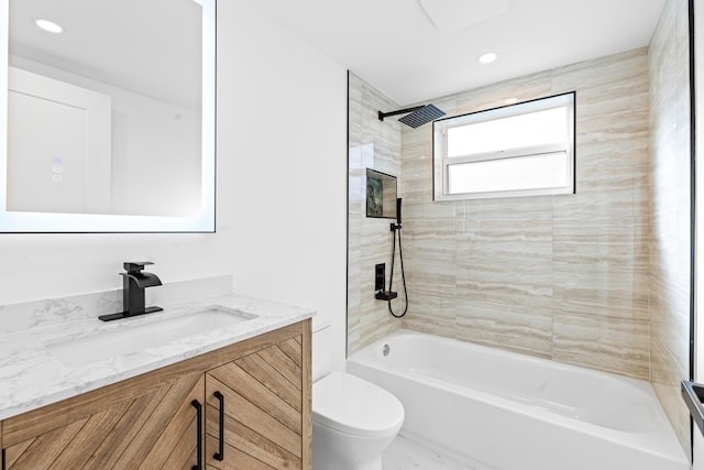 full bathroom with vanity, tiled shower / bath combo, and toilet